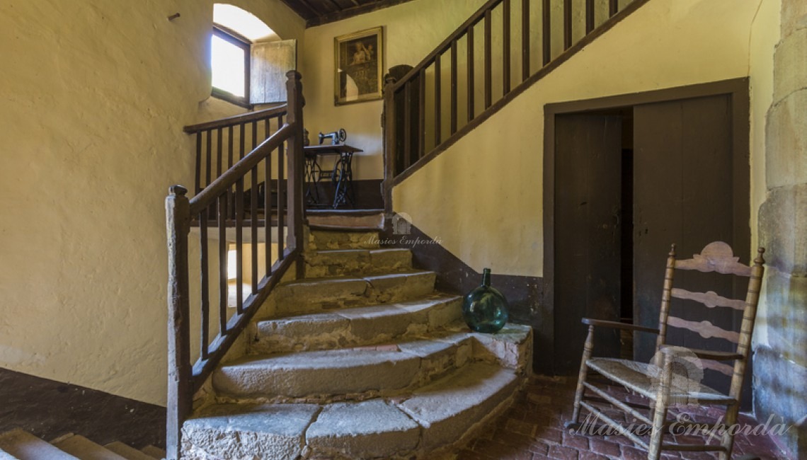 Hall de entrada a la segunda planta y escalera con escalones redondeados que dan acceso a la tercera planta de la casa