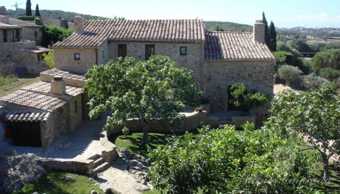 Vista del conjunto arquitectónico de la masía, porches y anexo está rodeada del jardín ubicada finca ubicada en Begur, Baix Empordà