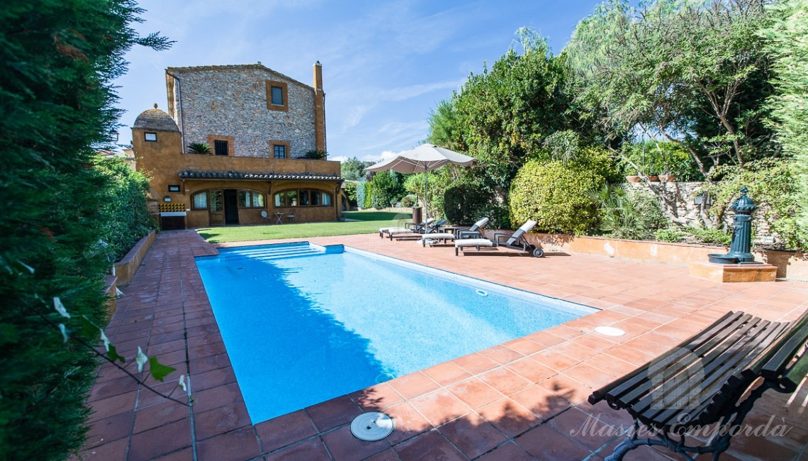 Vistes de la piscina, jardí i la casa a fons de la imatge