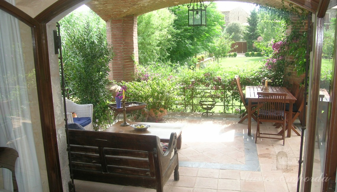 Vista des de l'interior de la casa de porxo i el jardí