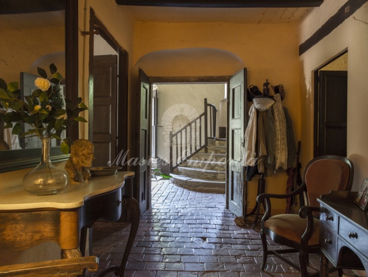 Vista desde el pasillo interior del salón del Hall de entrada a la segunda planta y escalera con escalones redondeados que dan acceso a la tercera planta de la casa