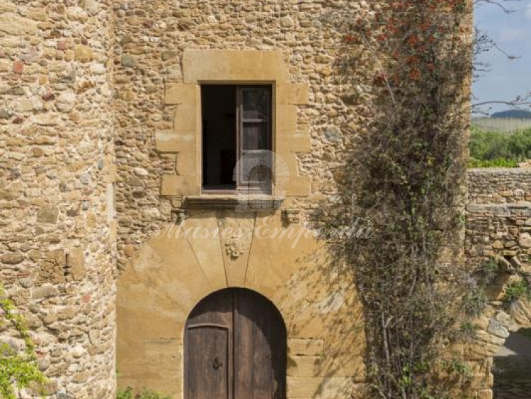 Detalle de la entrada principal de la Masía con arco en piedra tallada 